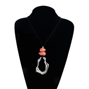 Detail view of the irregular geometric hollow metal pendant necklace with marbled beads.