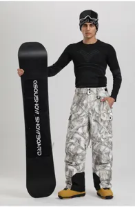Detail view of winter outdoor cargo ski pants with waterproof fabric and camo design.