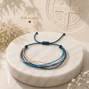 Vista dettagliata del bracciale intrecciato a più fili blu e beige su marmo.