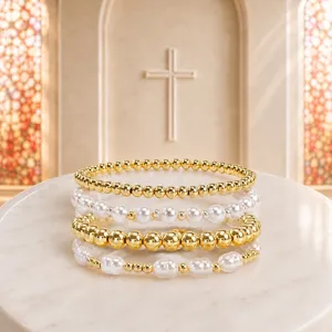 Vue détaillée de perles dorées et de perles blanches, design de bracelet de mode élégant.