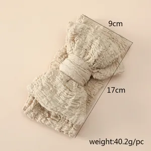 Vue détaillée bandeau bébé nœud froissé, tissu crêpe beige doux, dimensions 9x17cm.