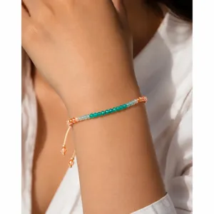 Close-up detailopname van een kleurrijke glazen kralenarmband met verstelbare knopen.