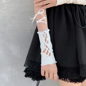 Vista di dettaglio di manicotti bianchi in maglia con allacciatura, Lolita.