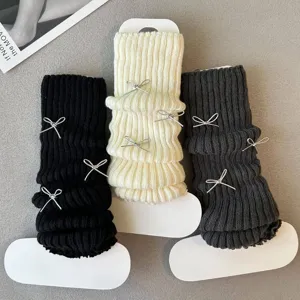 Knit leg warmers detail featuring cute silver bows and cozy style for winter outfits.