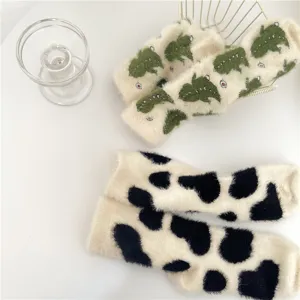 Detailed view of cozy plush fleece winter socks with cute dinosaur and cow print designs.
