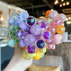Détail de chouchous à perles de cristal colorées, attaches pour queue de cheval élastiques.