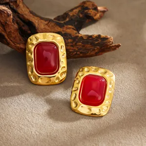 Vue détaillée de boucles d'oreilles carrées dorées style rétro avec pierre rouge chic.