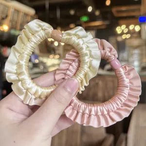 Dettaglio di elastici per capelli in satin con volant, accessori per acconciature dolci e chic.