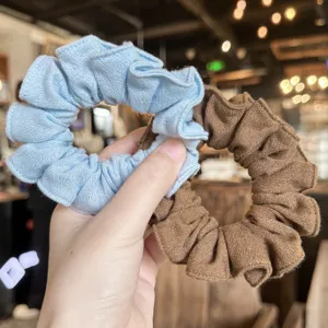 Primer plano detallado de coleteros de lino en azul y marron para peinados elegantes.