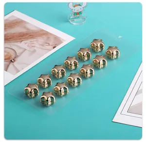 Nahaufnahme Detailansicht glänzender goldener Stern Magnet Schal Clips auf Karte.