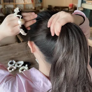 Elegant black and white ruffled hair scrunchie with a large pearl decoration for women.