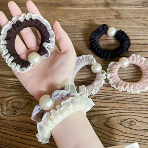 Detailed view of elegant ruffled pearl hair scrunchies in various colors for women.