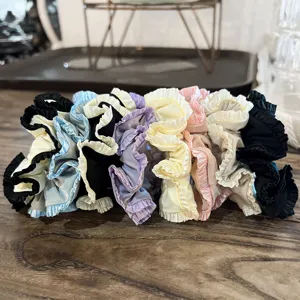 Close-up of colorful satin ruffle hair scrunchies detail, showing delicate pleated fabric texture.