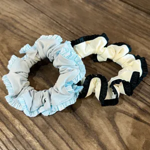 Detailed shot of two stylish silk hair scrunchies with delicate ruffled lace edges, ideal.