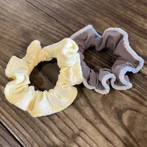 Close-up details of vintage velvet hair scrunchies with white plush lace trim for elegant styles.