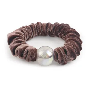 Detailed shot of brown velvet hair scrunchie featuring a glowing glitter decorative bead accent.