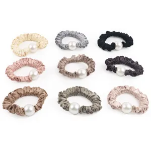 Détail chouchous cheveux perle en satin, design plissé élégant, accessoires cheveux femme.