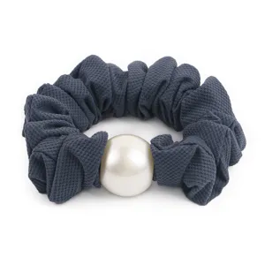 Elegant dark grey fabric hair scrunchie featuring a large central white pearl accent.
