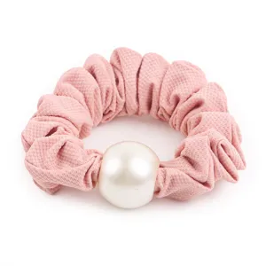 Detailed shot of a pink scrunchie featuring a large elegant faux pearl decoration charm.