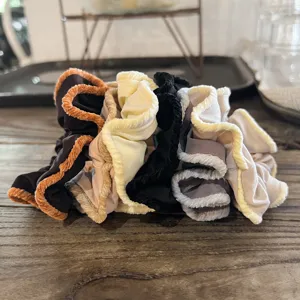 Detailed view of vintage velvet hair scrunchies with contrast ruffle edges, soft autumn styles.