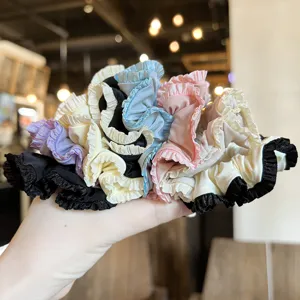Close-up detail of multi-color ruffled satin hair scrunchies showing texture and color variety.