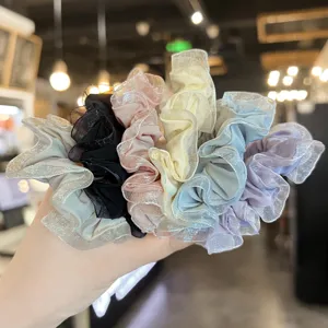 Gros plan de chouchous froncés en organza brillant multicolore avec bande élastique.
