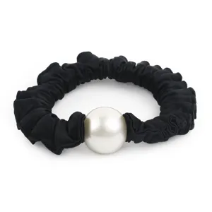 Détail d'un chouchou en satin noir avec perle blanche centrale pour coiffure élégante.