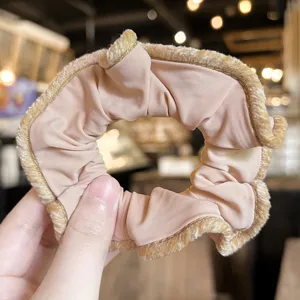 Close-up detail of vintage velvet lace hair scrunchie, elegant nude brown elastic hair tie.