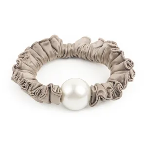 Détail rapproché du chouchou pour cheveux en satin élégant avec une grosse perle.