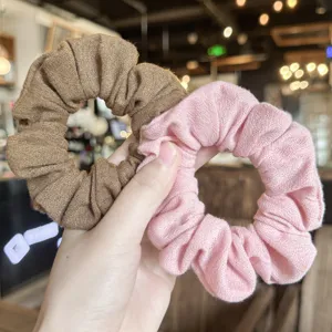 Detalle de coleteros de pelo con textura de lino, accesorios capilares elegantes y dulces.