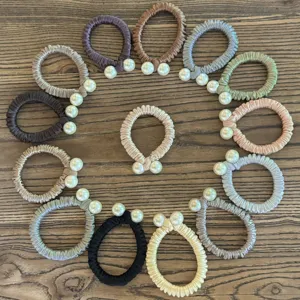Vue détaillée de chouchous en satin multicolore ornés de perles doubles pour coiffure.