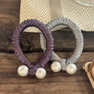 Vue détaillée de chouchous en satin élégants avec perles doubles, accessoires chics.