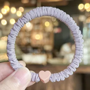 Koreanisches minimalistisches lilanes Stoff-Haargummi mit rosa Herz-Anhänger für Damen.