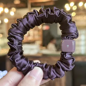 Chouchou de cheveux en satin violet foncé avec charm carré assorti, détail accessoire coiffure.