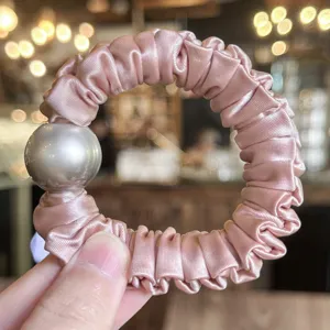 Pink satin hair scrunchie with large pearl accent, elegant high elasticity hair tie for women.