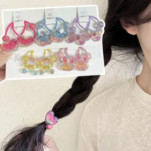 Primer plano detallado de lindas ligas para el cabello con purpurina y motivos en cartón.