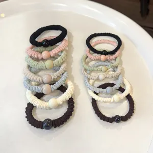 Detail view of soft pleated hair scrunchies with bead decoration, elastic hair tie accessories.