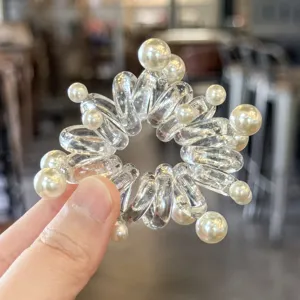 Elastico per capelli trasparente a spirale con perle, dettaglio di fermaglio estivo.