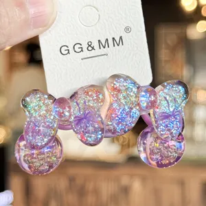 Détail en gros plan de l'élastique à cheveux nœud scintillant violet avec des pendentifs en résine.