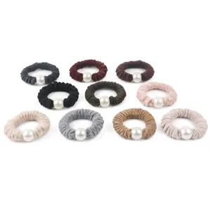 Detailed view of winter woolen scrunchies with elegant faux pearl accents, soft fabric hair ties.