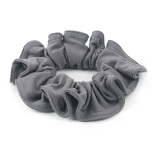 Elastico per capelli in camoscio grigio, dettaglio, accessorio minimalista design plissettato.