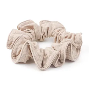 Detailed close-up of honeycomb ice silk minimalist hair scrunchie, beige fabric hair tie.