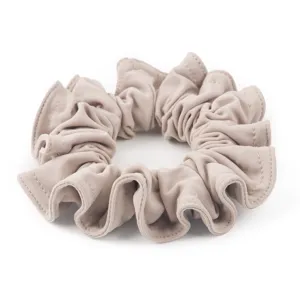 Dettaglio in primo piano dell'elastico per capelli in camoscio morbido con arricciature.