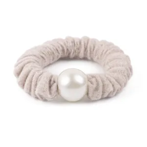 Detailed view of a chic wool textured hair scrunchie featuring a large pearl ornament.