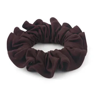 Dettaglio in primo piano dello scrunchie marrone, che mostra una morbida trama plissettata.