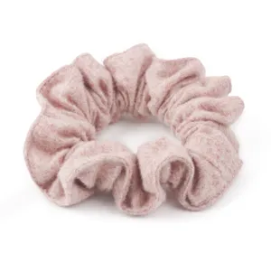 Primo piano dettagliato di un morbido scrunchie in lana rosa, trama soffice per acconciature.