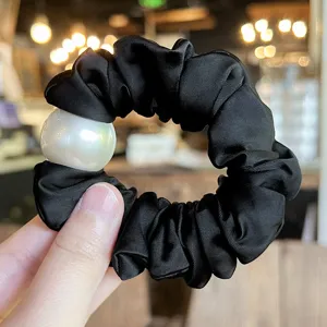 Black satin hair scrunchie with large pearl detail, elegant elastic hair band for daily wear.