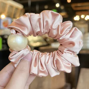 Pink satin hair scrunchie with a large pearl, elegant elastic hair band for daily styling.