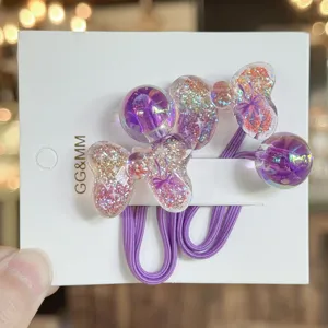 Detailansicht niedlicher Kinder Haargummis mit glitzernden Schleifen und lila Bändern.