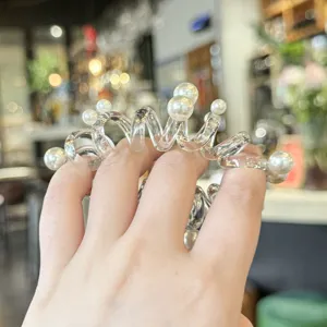 Dettaglio di elastico per capelli trasparente con perle per lo styling estivo.